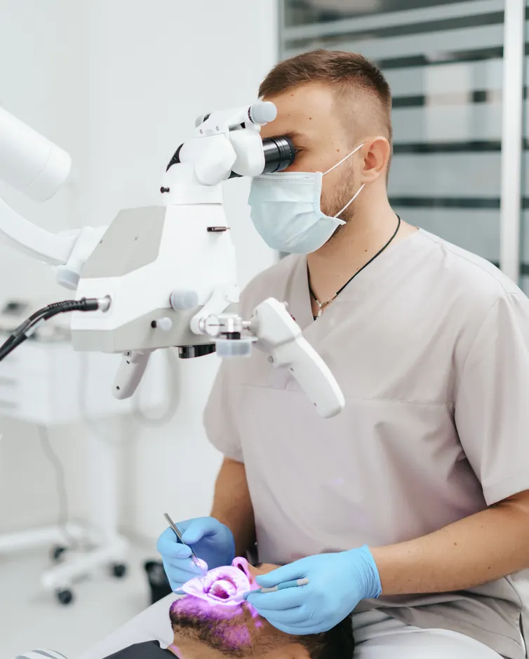 Dentist working with a dental microscope